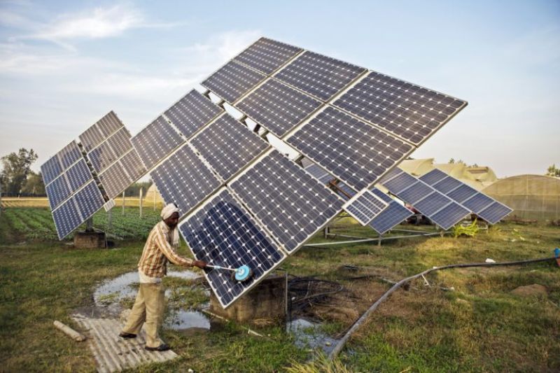 A farmworker cleans the solar panels of a solar water pump at the farm-49d7ed8596bb6135bff81de7c74ed7221622879293.jpg